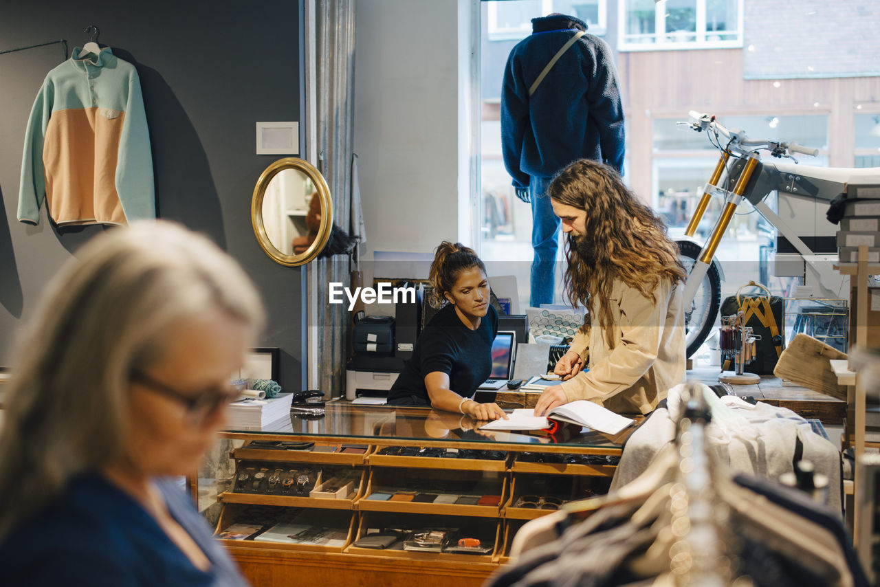 Female and male colleagues discussing in clothing store