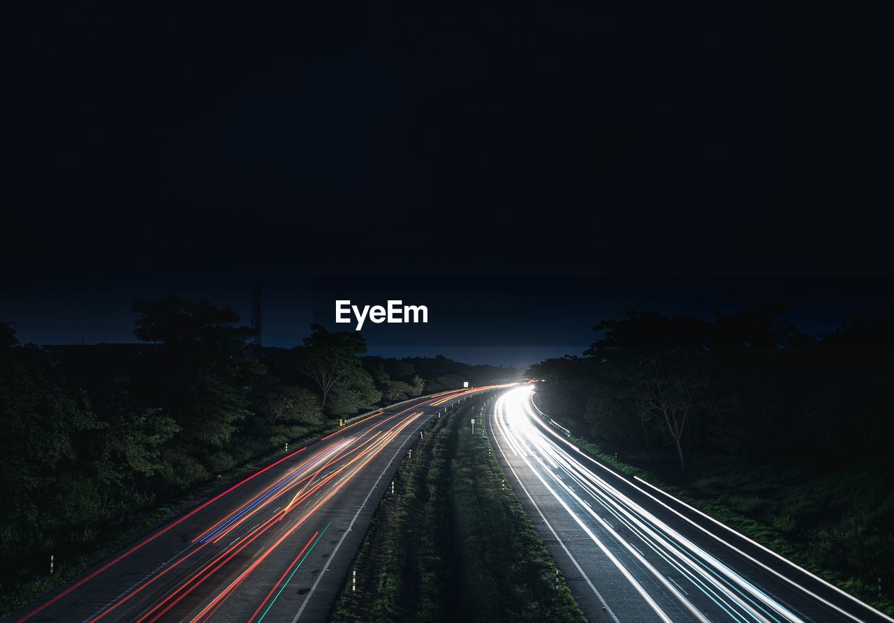 High angle view of light trails on highway at night