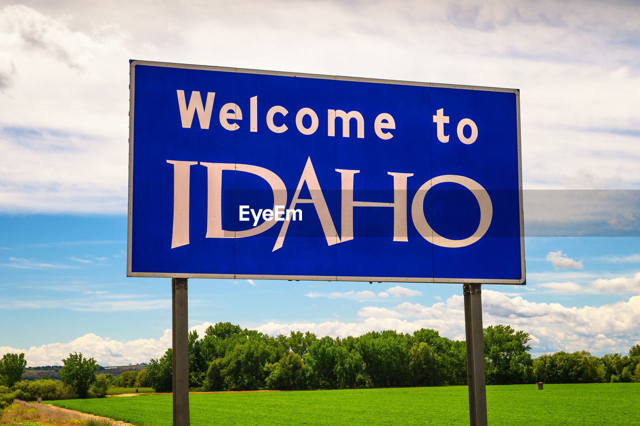 low angle view of road sign against cloudy sky