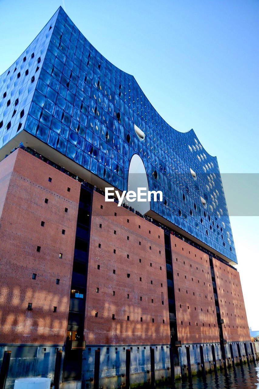 Low angle view of modern building against blue sky