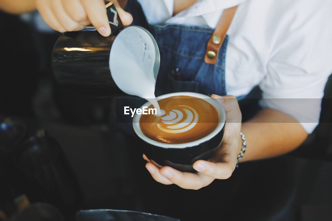 Midsection of man holding coffee