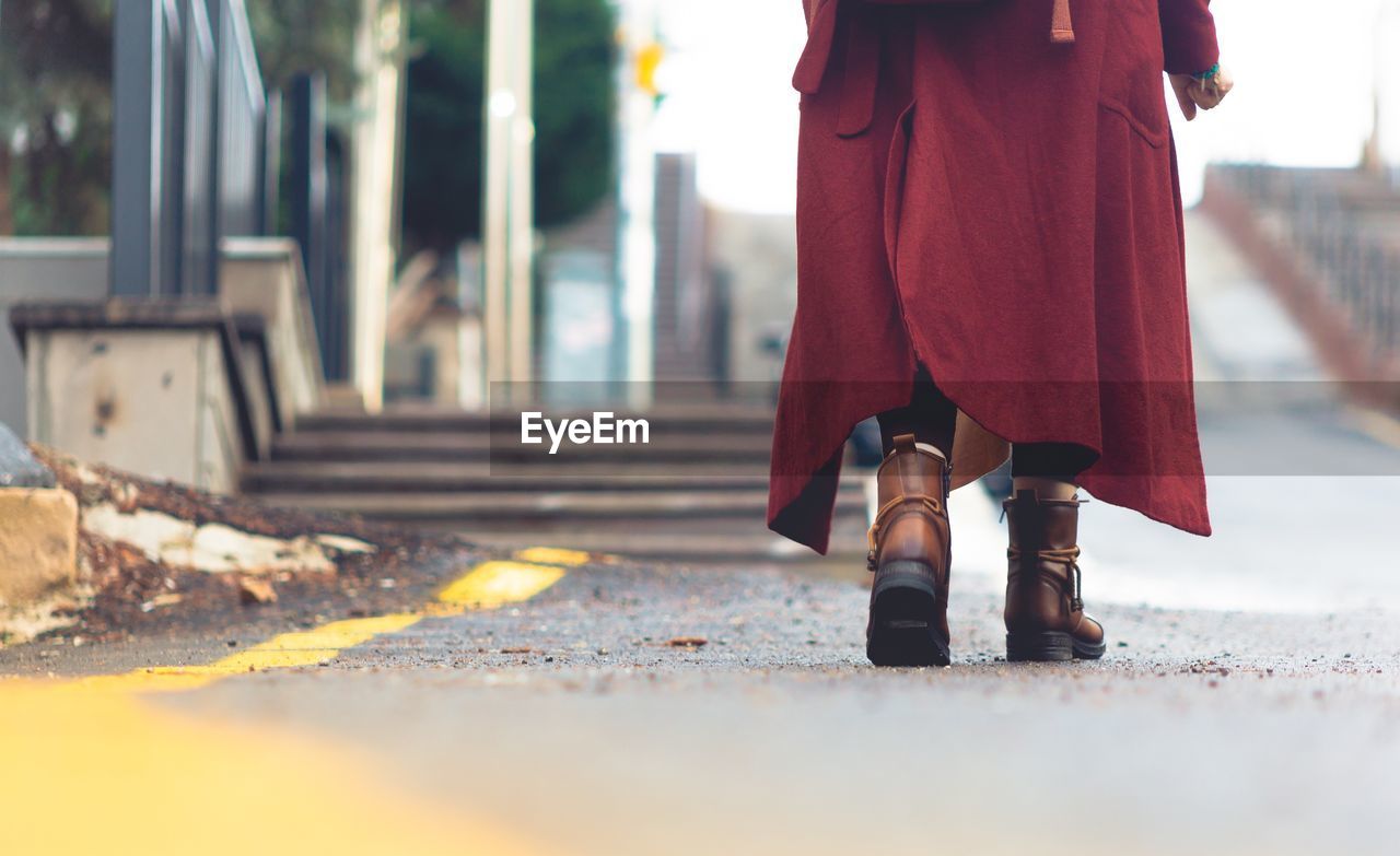 Low section of woman walking on road