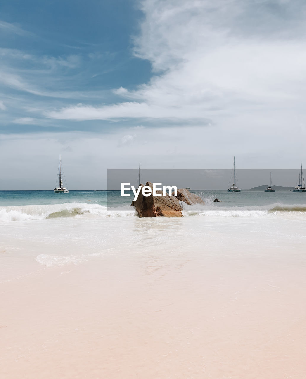 Sandy beach, sailboats on horizon, light and airy.