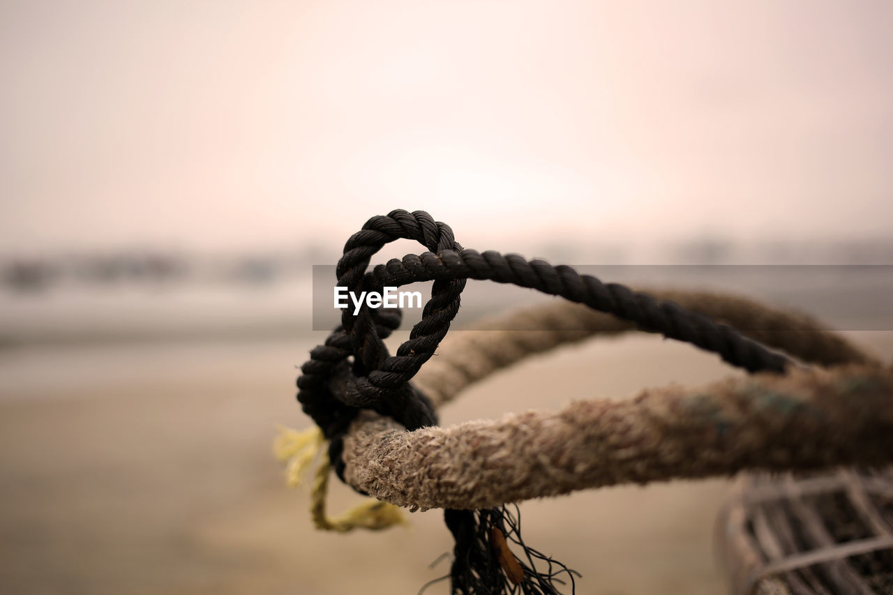 Close-up of ropes tied up at beach