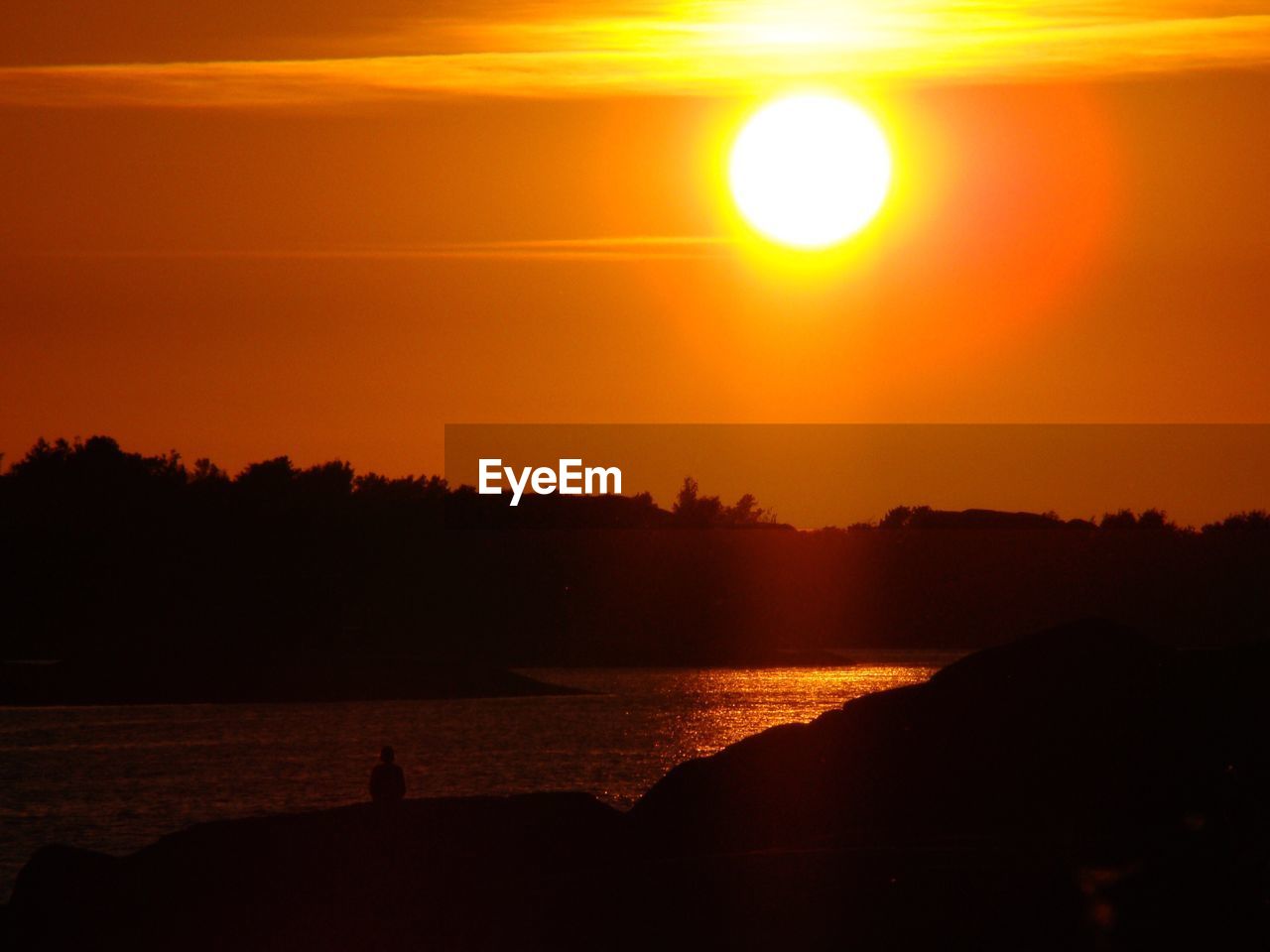 SCENIC VIEW OF CALM SEA AGAINST ORANGE SKY