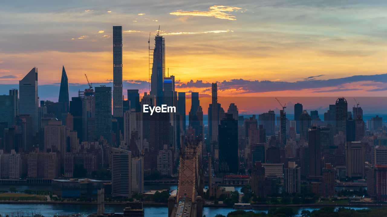 Aerial view of modern buildings against sky during sunset