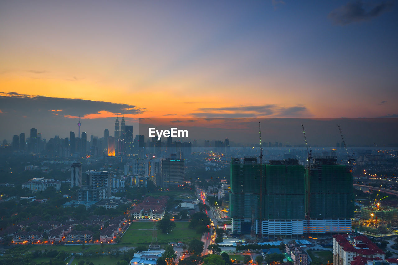 High angle view of illuminated buildings against sky during sunset