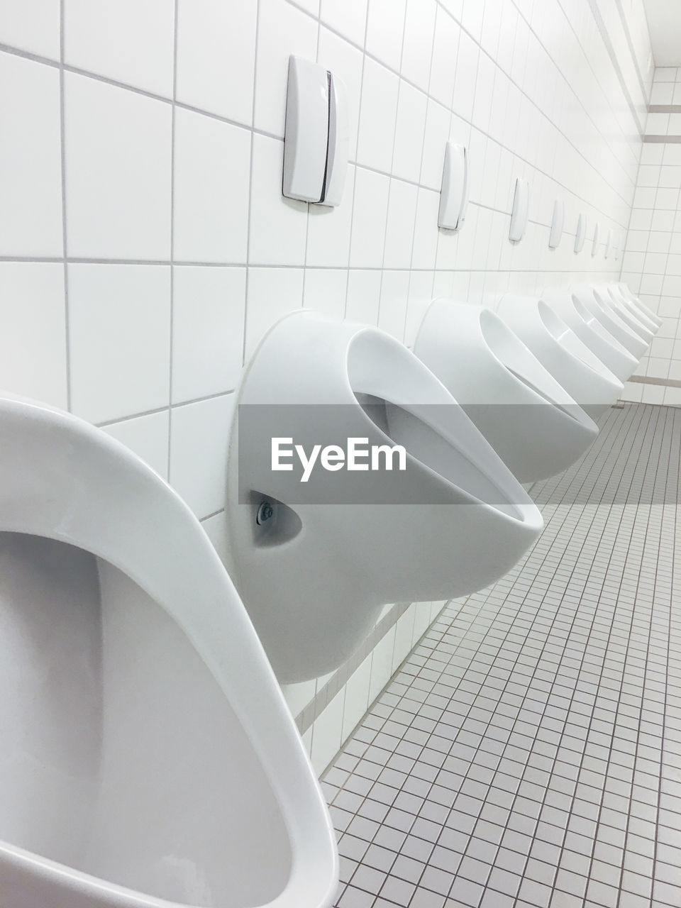 Close-up of urinals in bathroom