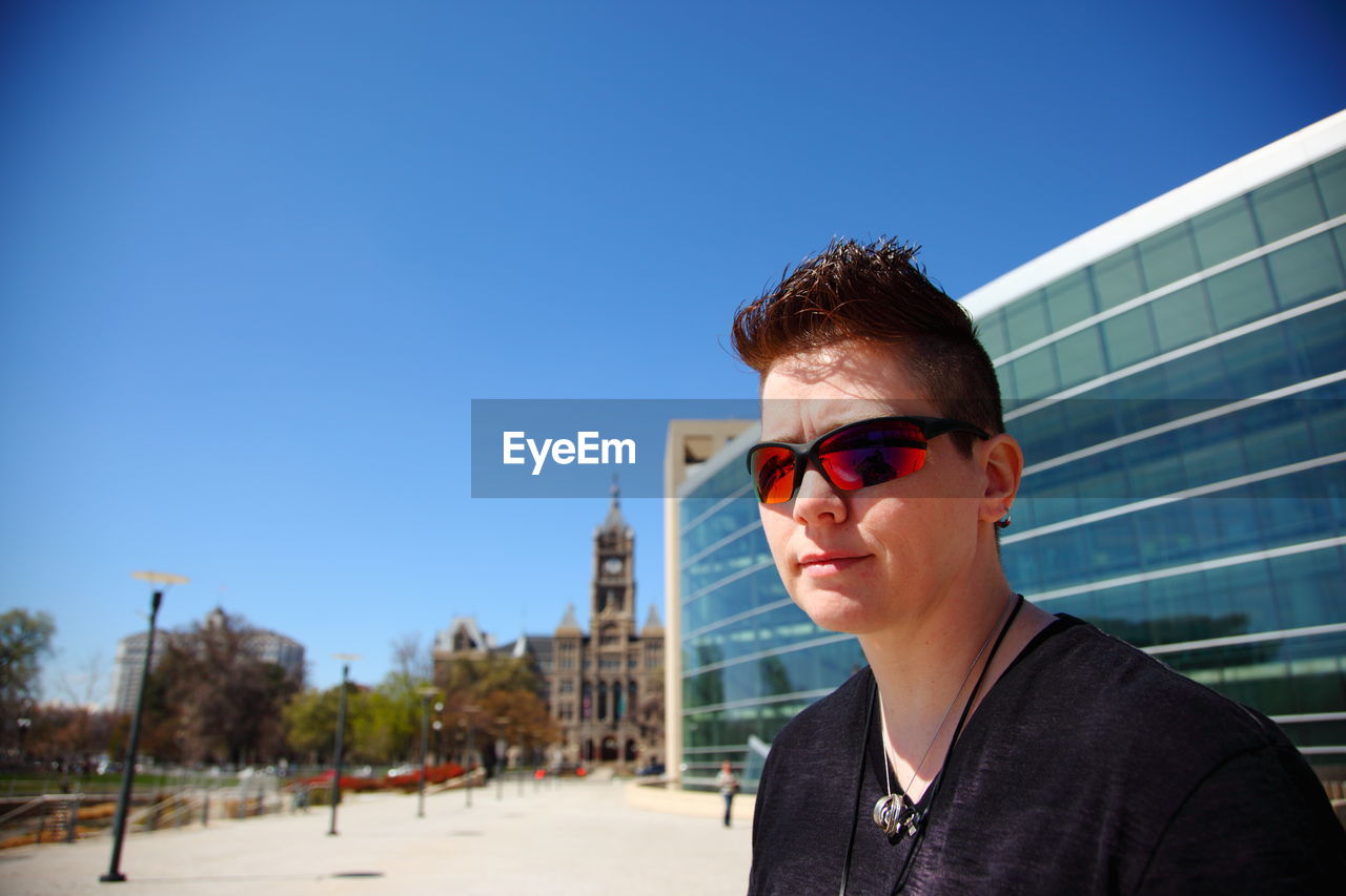 Portrait of young woman wearing sunglasses in city