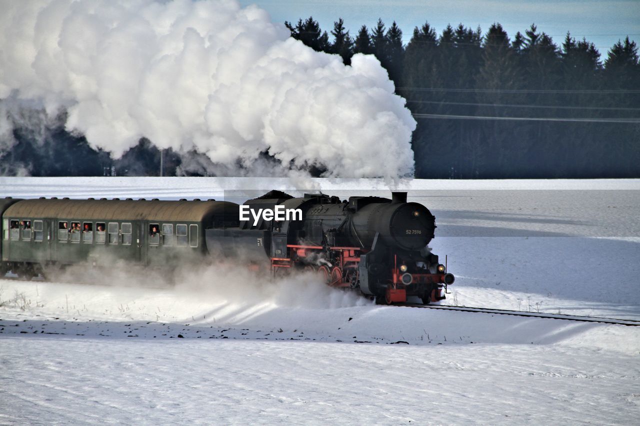 Train on railroad track against sky during winter