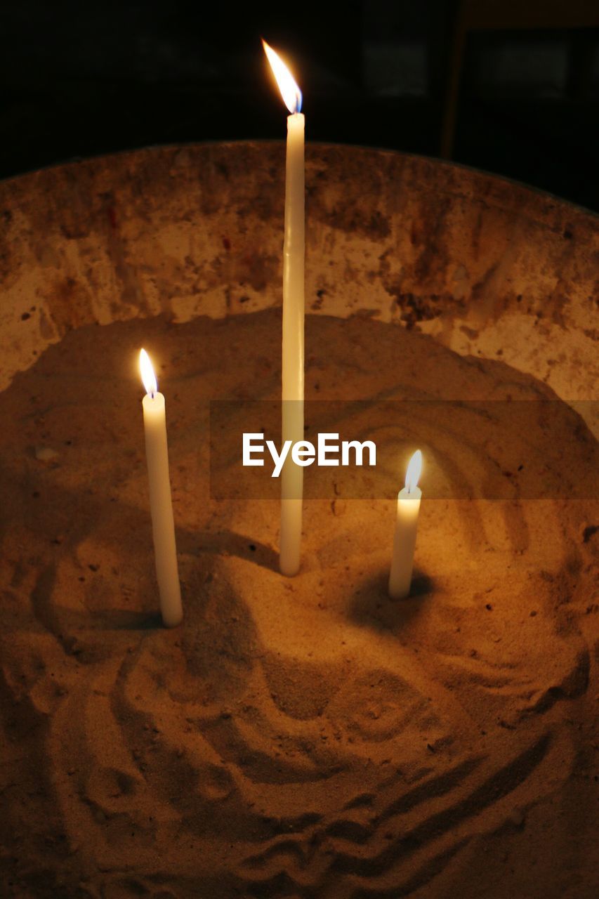 CLOSE-UP OF LIT CANDLES IN FIRE