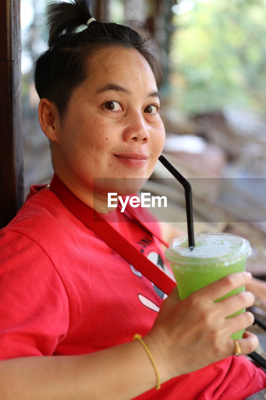 Portrait of mid adult woman drinking juice