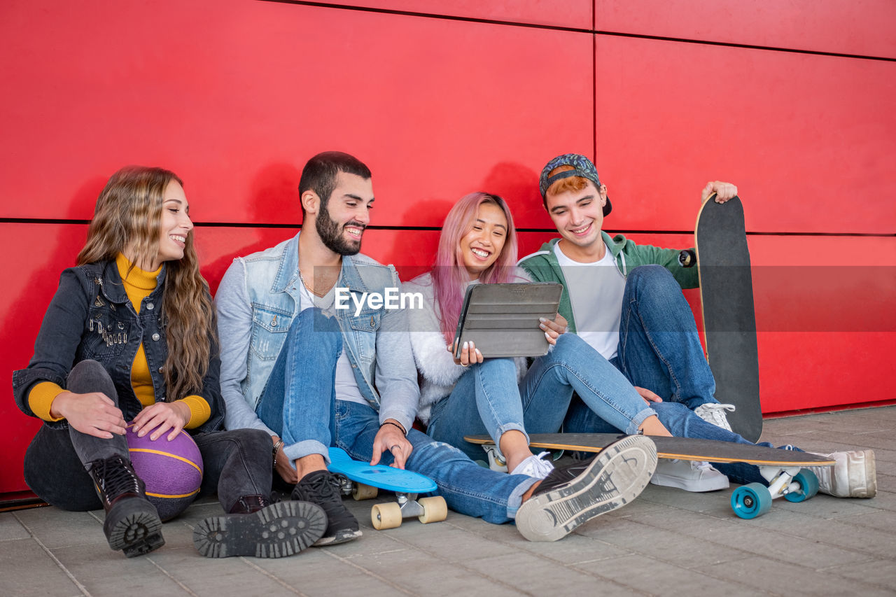 Young couple sitting by wall