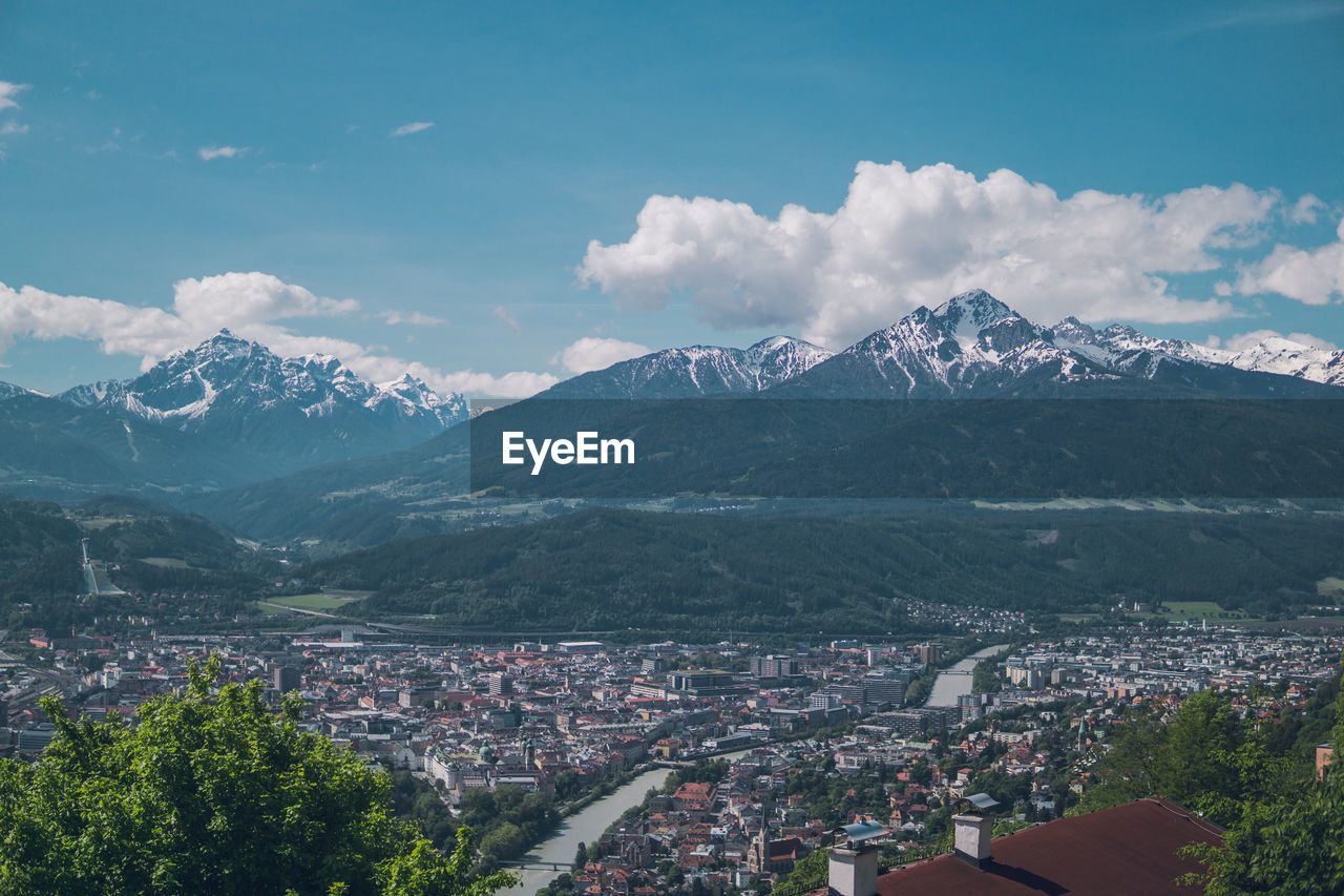 AERIAL VIEW OF TOWNSCAPE AGAINST MOUNTAINS