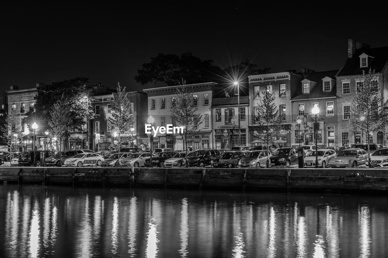 ILLUMINATED BUILDING BY RIVER AT NIGHT