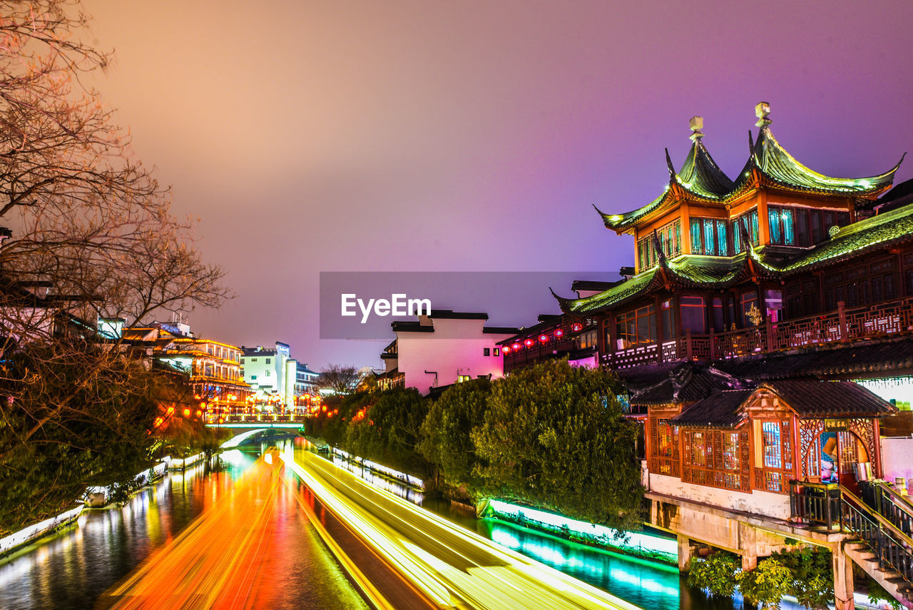 High angle view of light trails along built structures on urban street