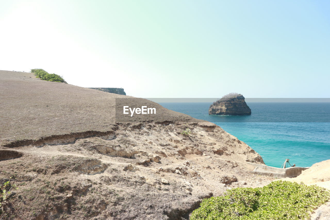 SCENIC VIEW OF ROCKS ON BEACH AGAINST CLEAR SKY