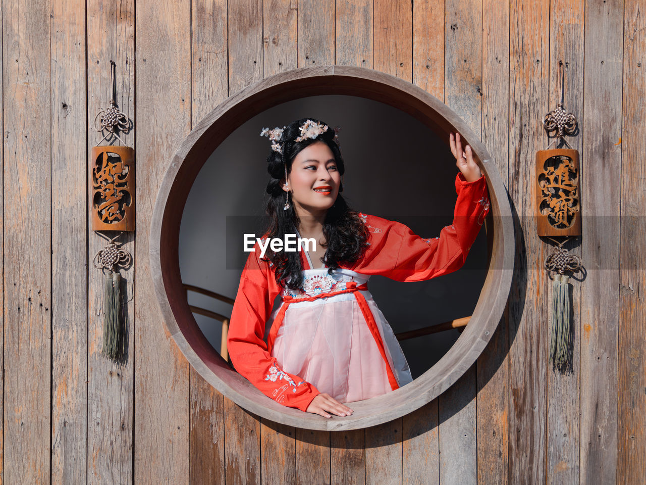 Asian woman tourist in red hanfu ancient chinese traditional ethnic costume looking out of window