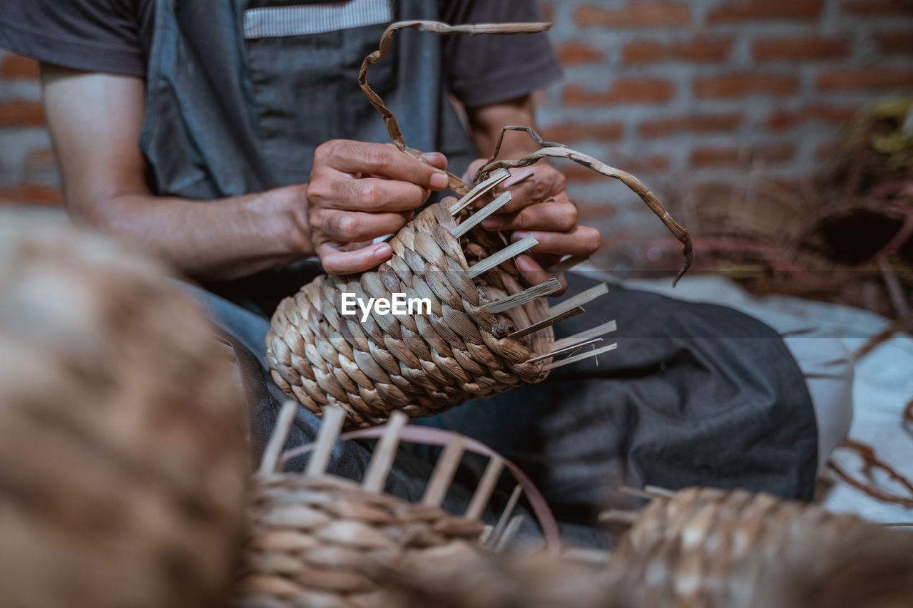 Midsection of man holding wicker basket