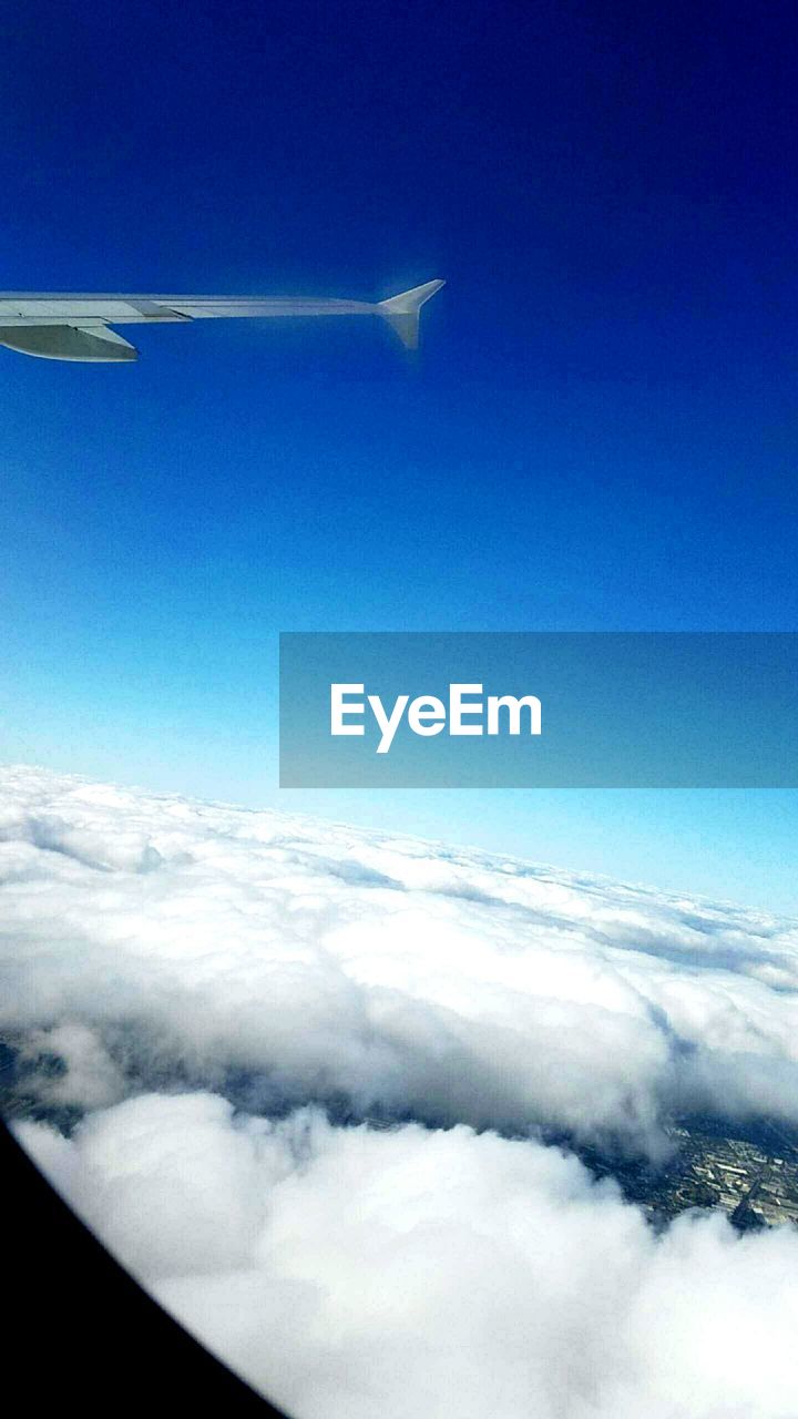 CROPPED IMAGE OF AIRPLANE WING OVER LANDSCAPE