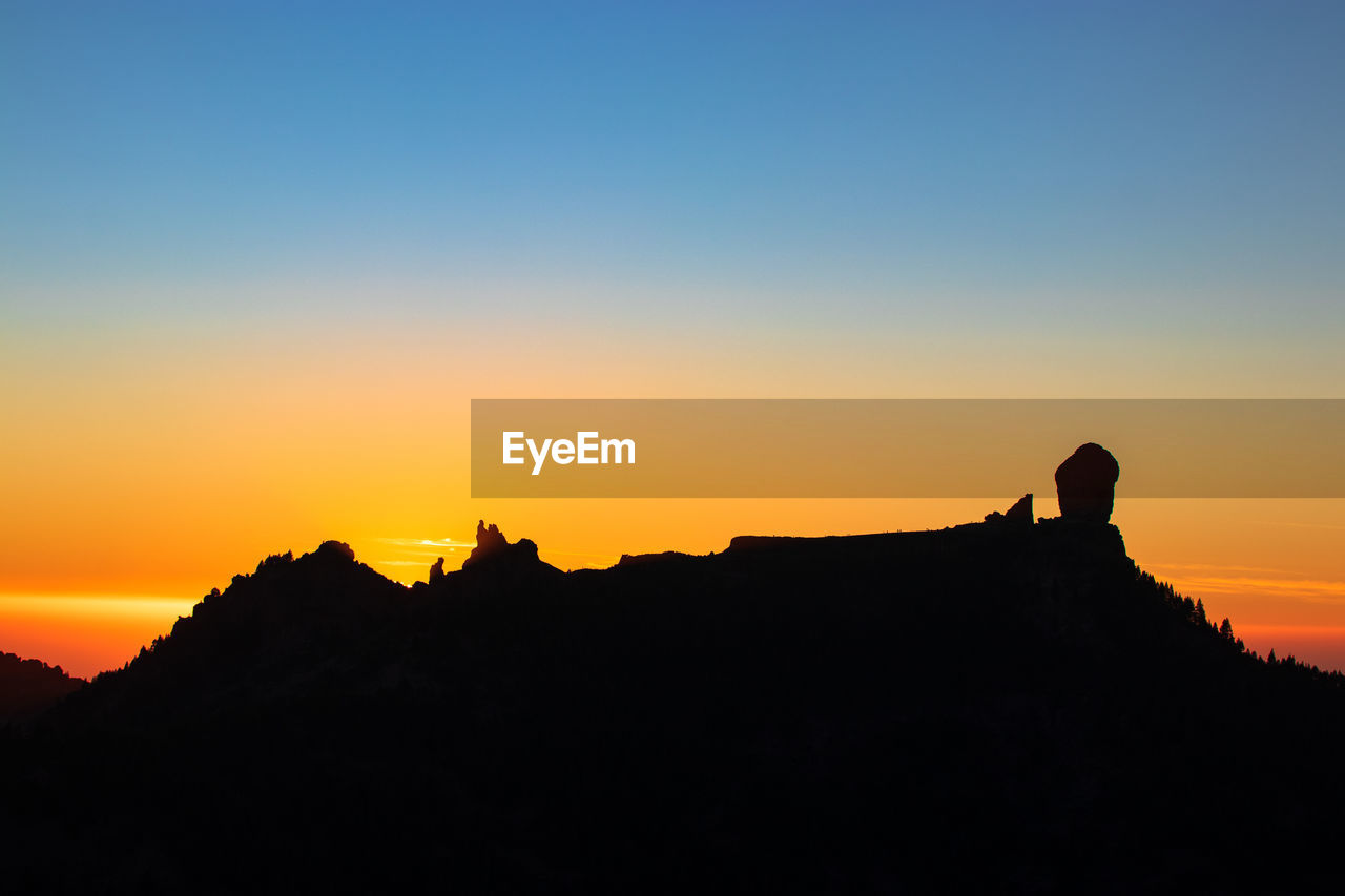 Silhouette mountain against clear sky during sunset