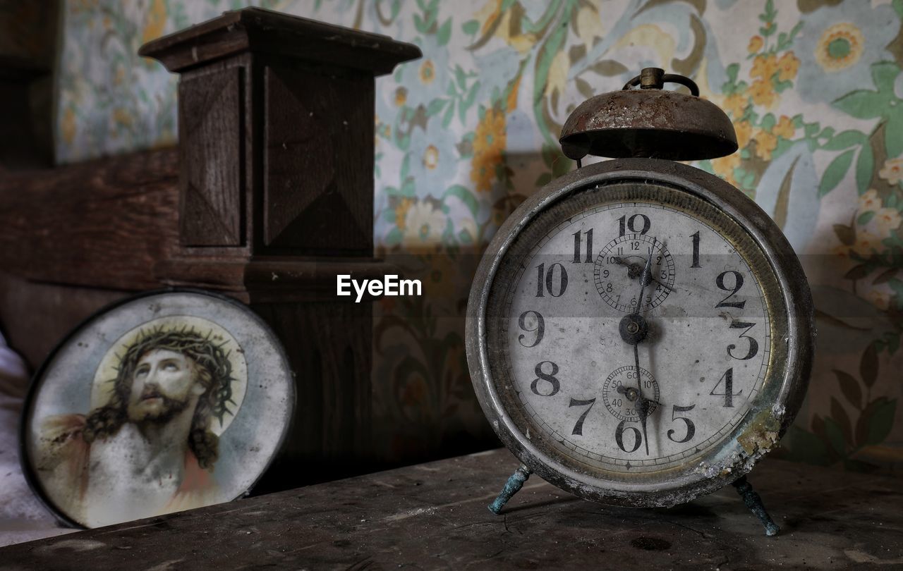 CLOSE-UP OF CLOCK ON OLD TABLE