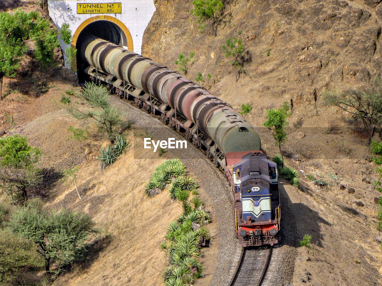 Diesel locomotive hauling a tanker rake through a tunnel on a railway line.