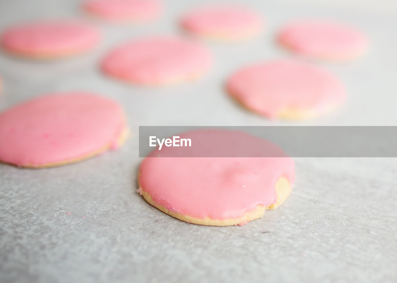Sugar cookies with pink frosting on gray kitchen island