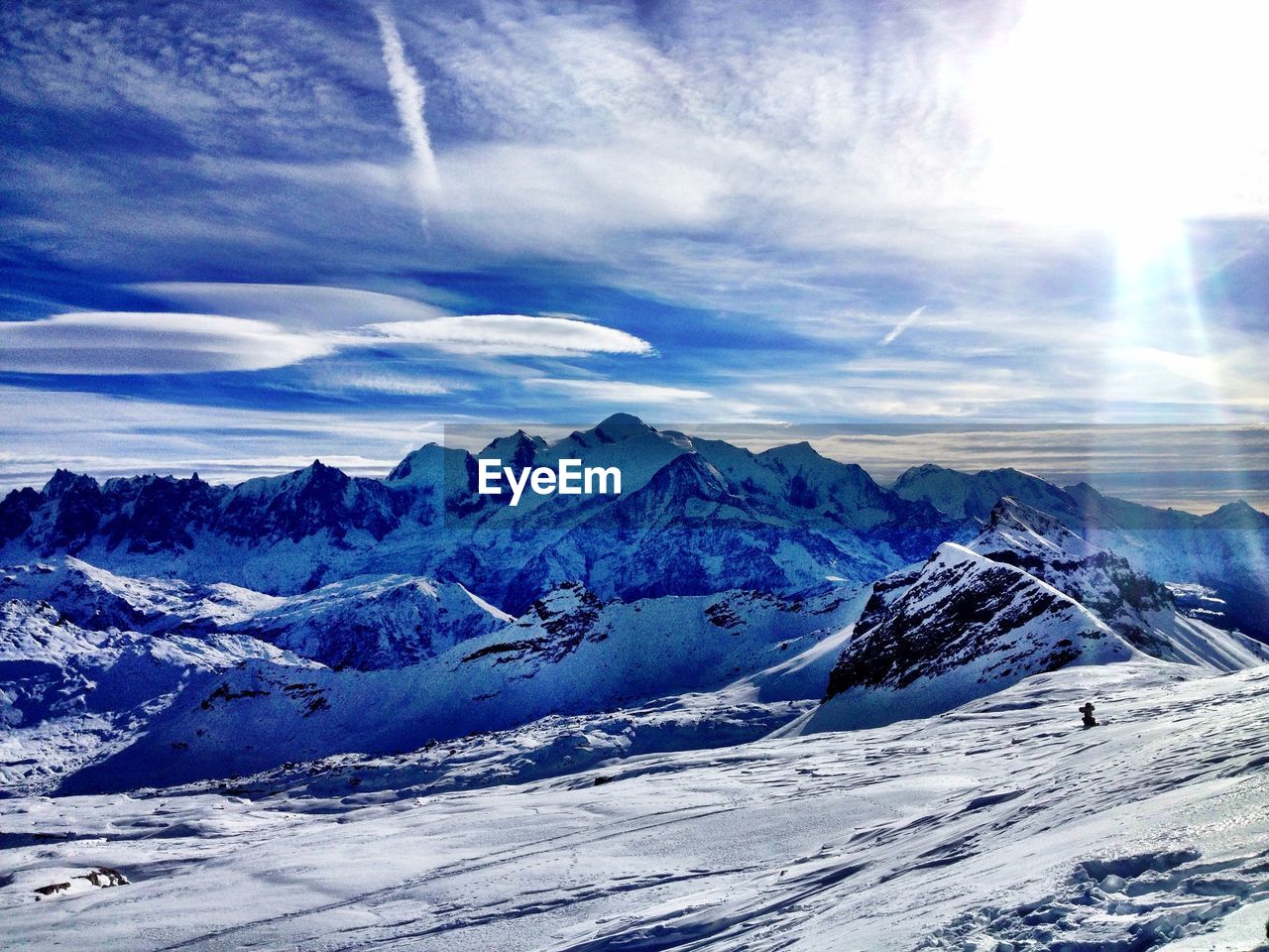 Scenic view of snowcapped mountains against cloudy sky