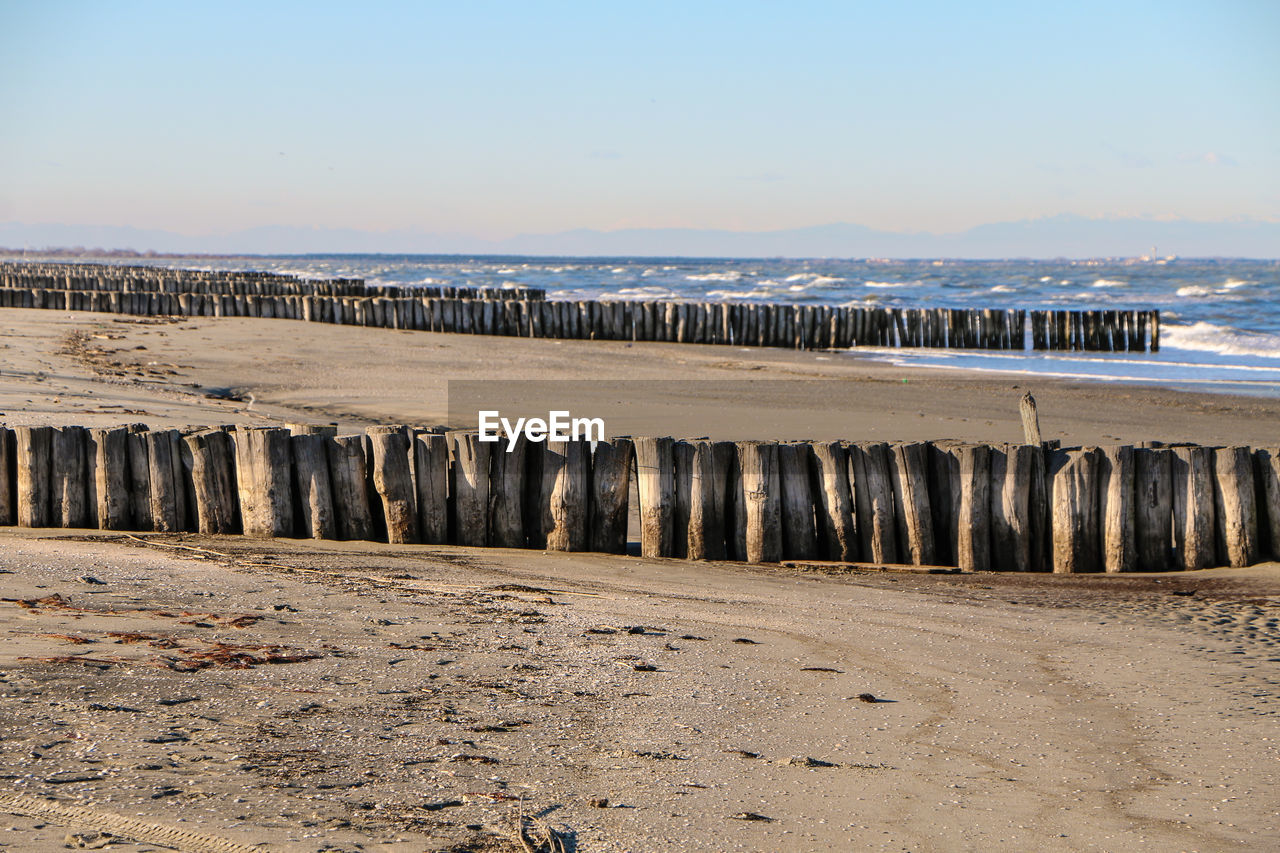 Groyne on beach against sky