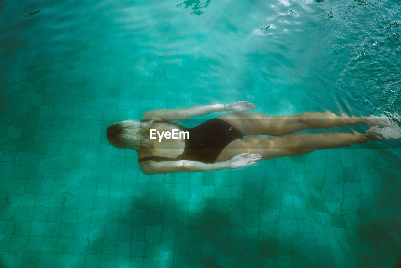 High angle view of young woman swimming in pool