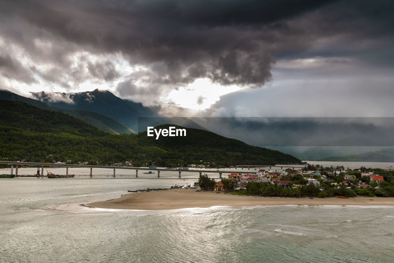 SCENIC VIEW OF SEA AGAINST MOUNTAINS