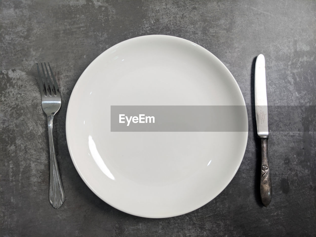 High angle view of empty plate with fork and spoon on table