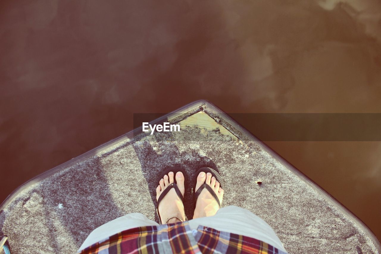 Low section of person standing on pier