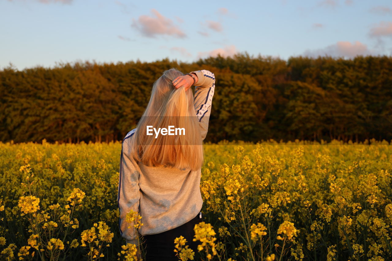 Rear view of teenager standing on field