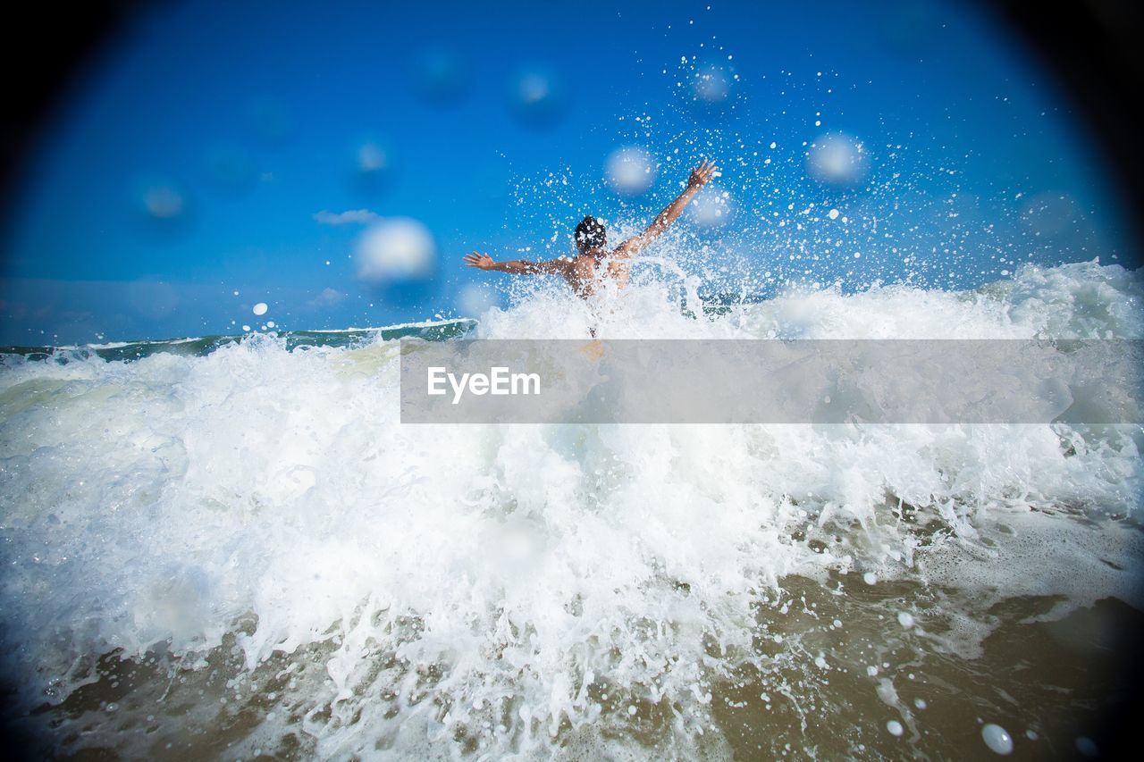 MAN SURFING ON SEA WAVES SPLASHING