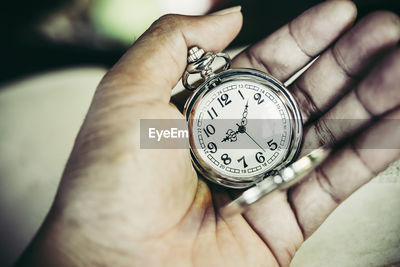 Hand holding pocket discount watch