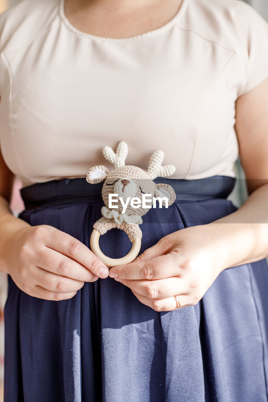 Midsection of woman holding toy