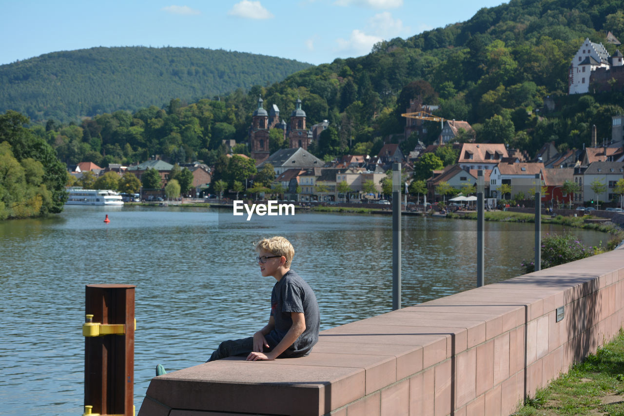 Boy  looking at river in miltenberg, germany 