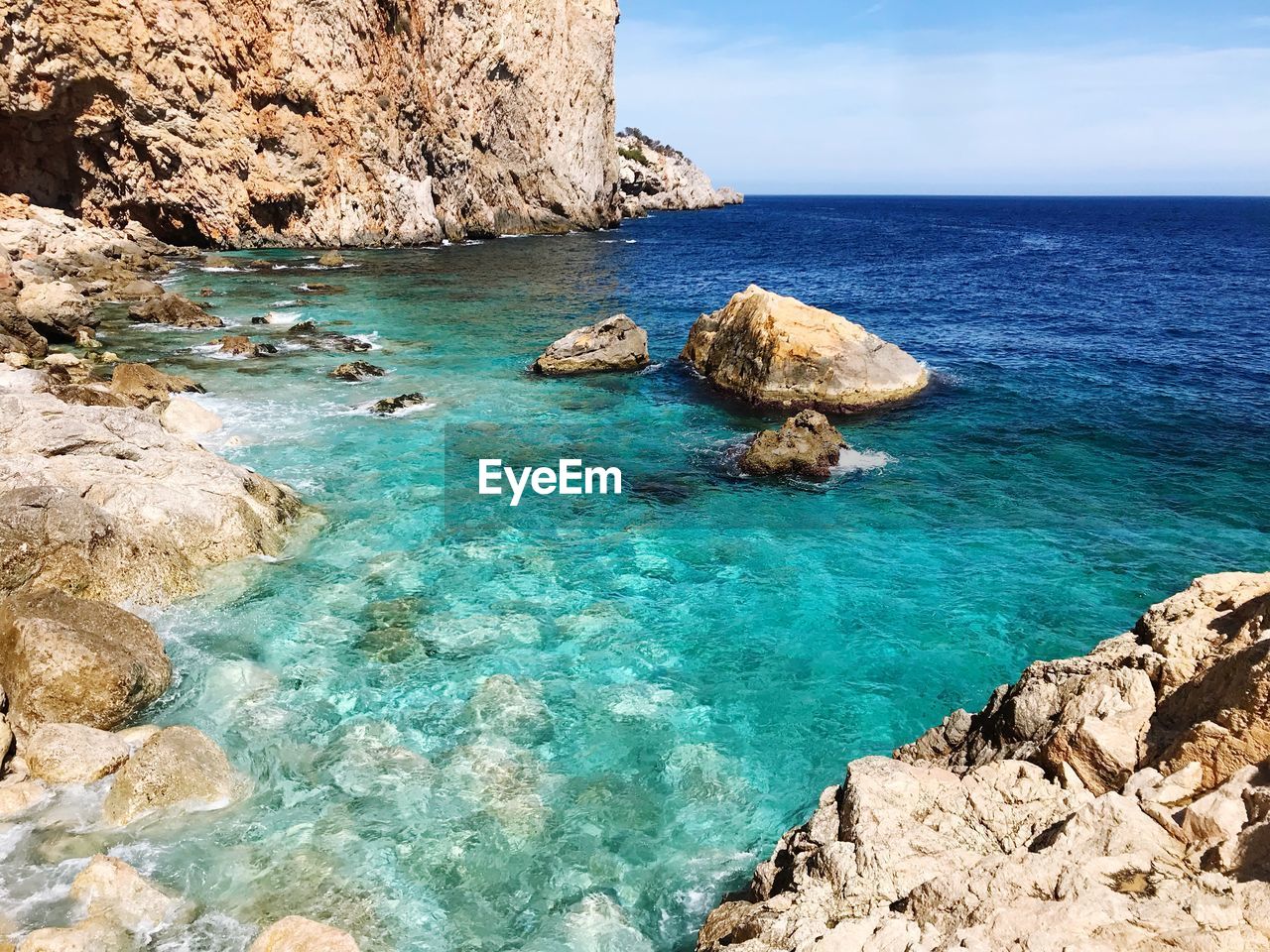 Scenic view of rocks in sea against sky