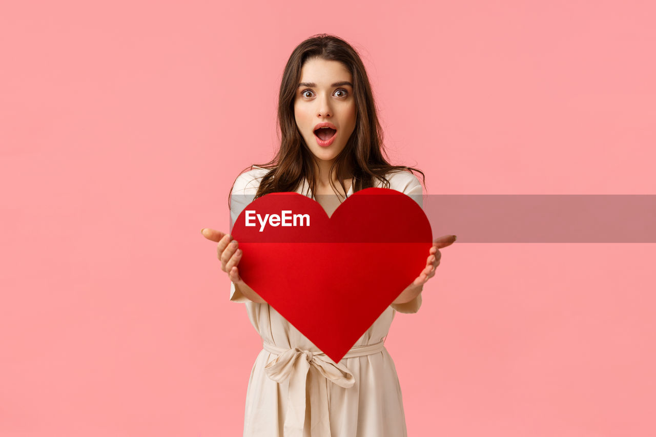 PORTRAIT OF WOMAN HOLDING RED HEART