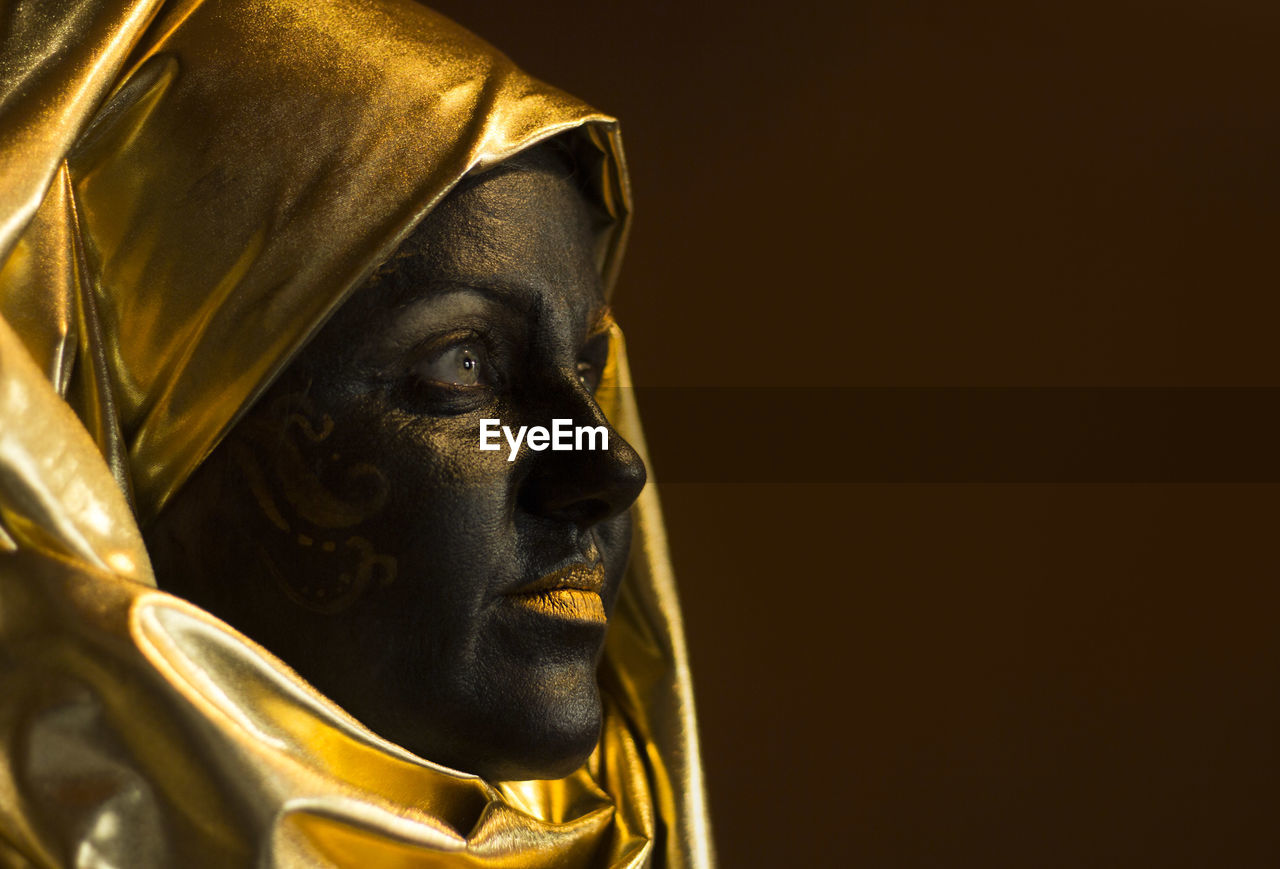 Portrait of a woman with black and gold make up, close up