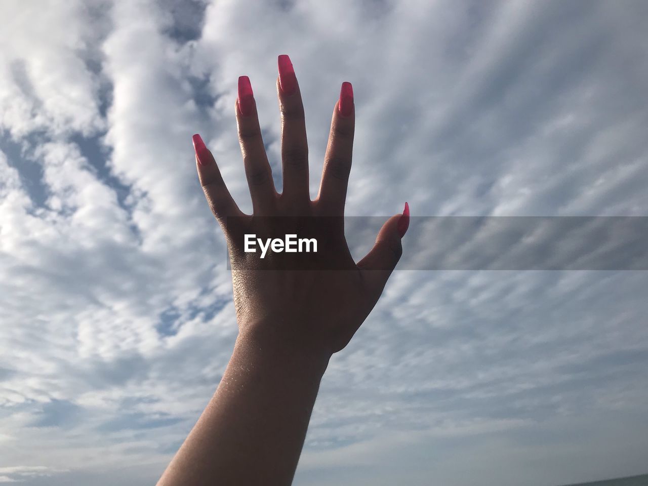 PERSON HAND AGAINST SKY