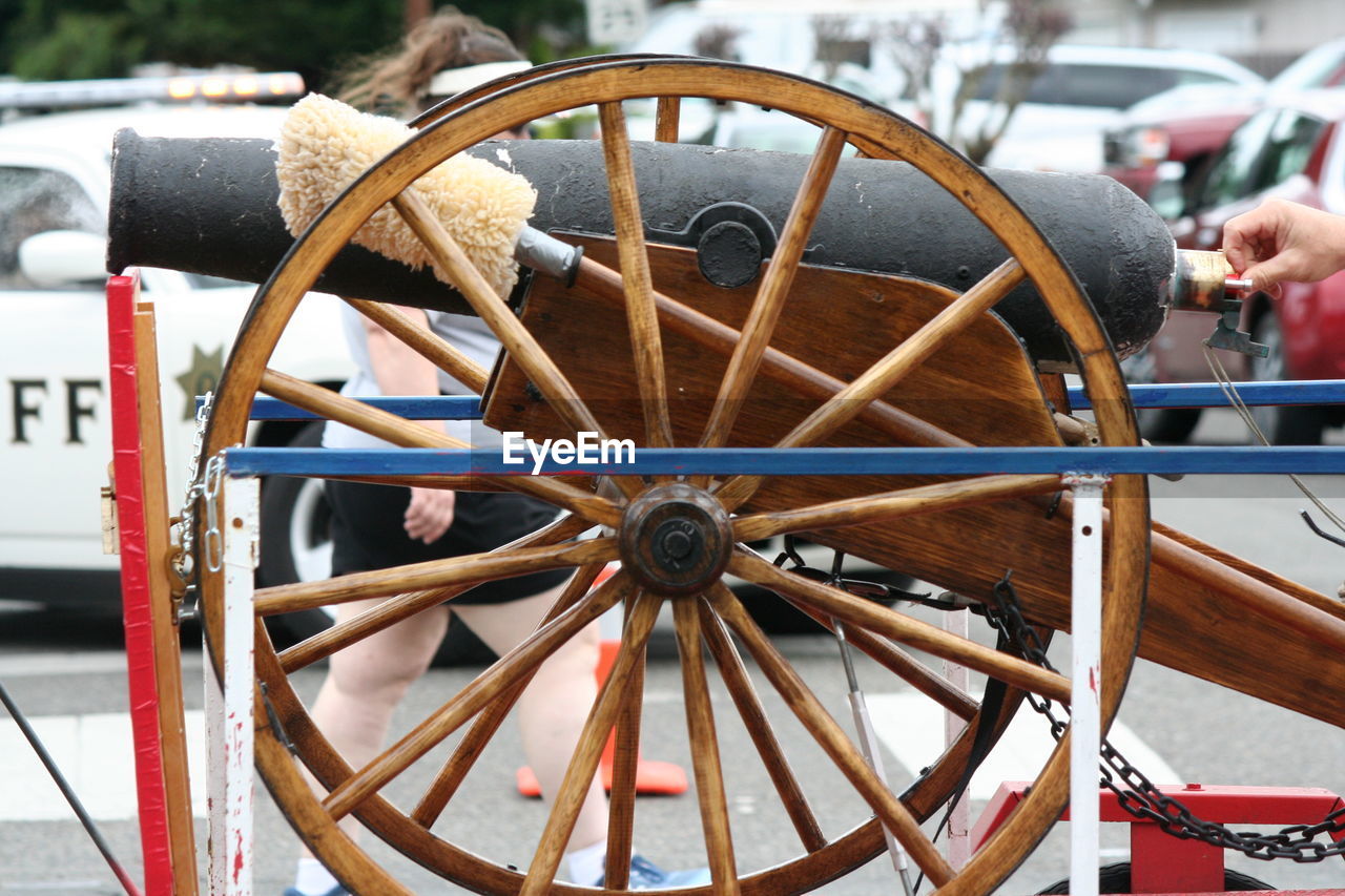 Cropped hand by cannon on street during fourth of july parade