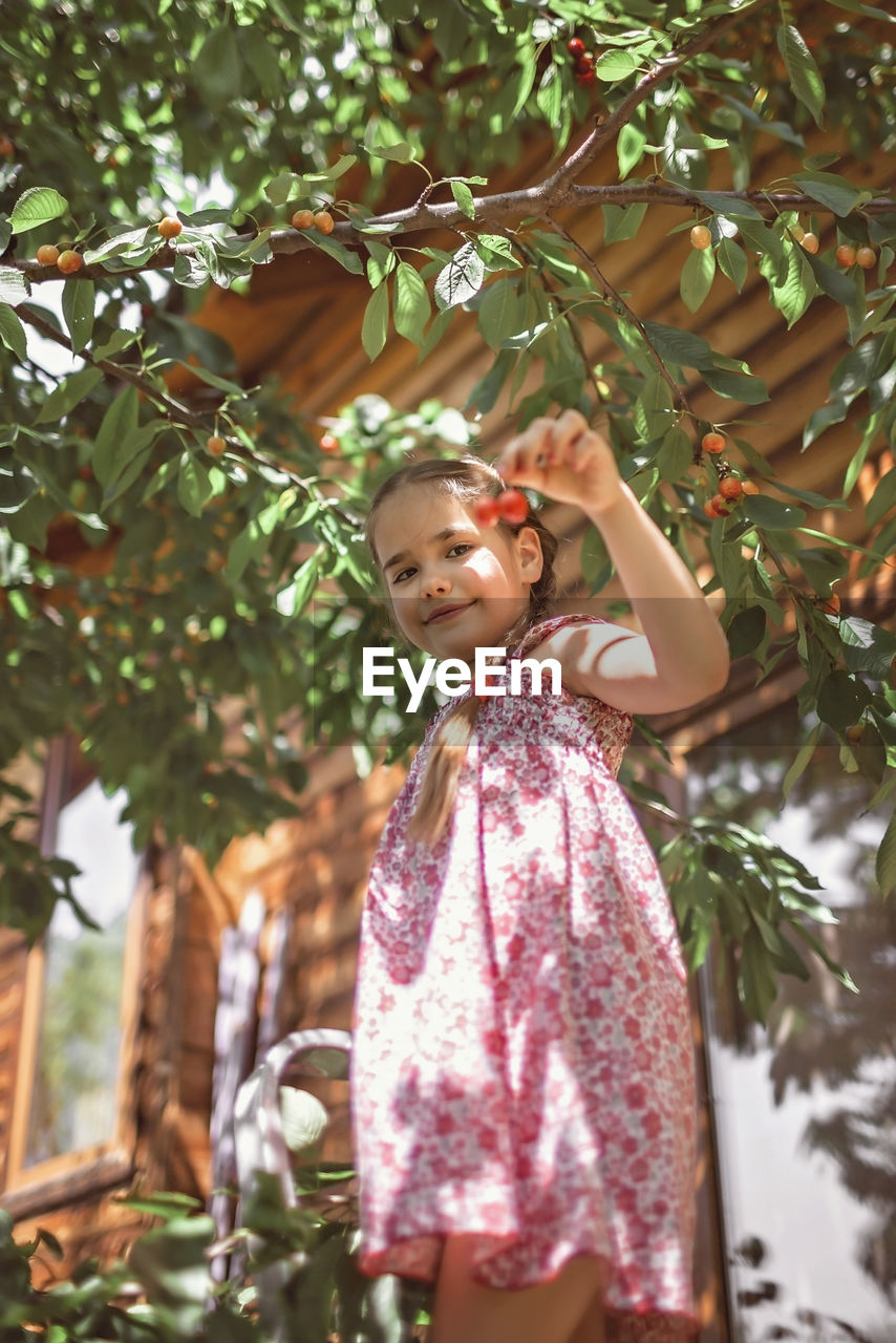 Full length of girl standing against plants