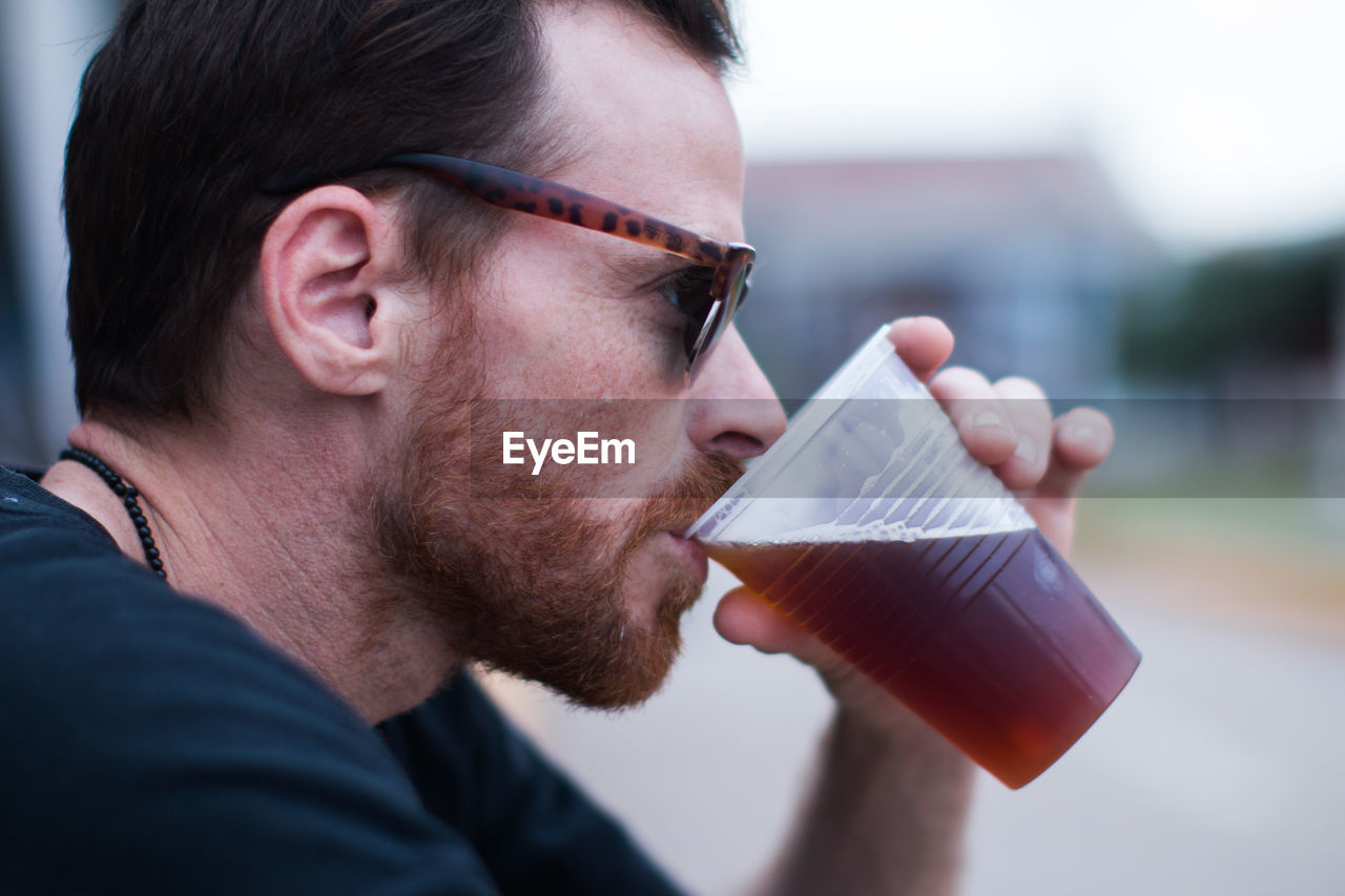 Close up portrait of bearded man drinking beer