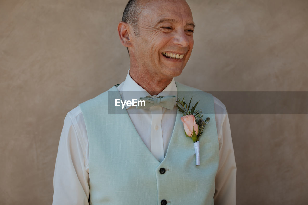 Portrait of smiling man standing against wall