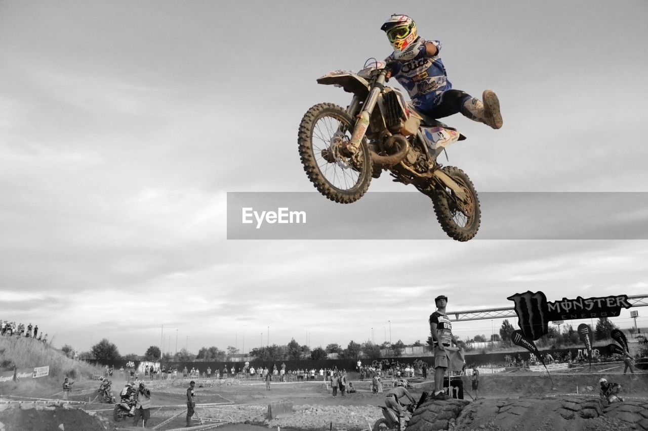 sports, mid-air, motocross, jumping, stunt, extreme sports, skill, motion, racing, competition, transportation, warning sign, mode of transportation, risk, sports helmet, motorsport, headwear, helmet, motorcycle racing, motorcycle, competitive sport, one person, performance, men, sports race, full length, adult, communication, sign, activity, sports equipment, adventure, biker, nature, leisure activity, professional sport, speed, person, expertise, sky, practicing, athlete, crash helmet, sports track, enduro, day, outdoors, driving, lifestyles, recreation, dirt, vehicle, stunt performer, riding, cloud, clothing