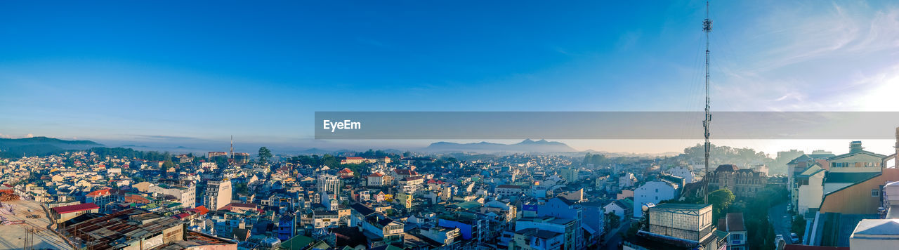 High angle view of city against blue sky