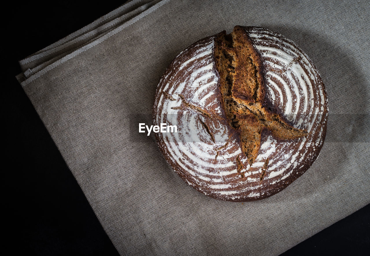 Directly above shot of bread on fabric on black background